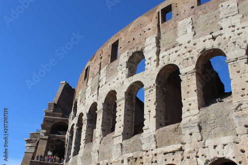 ROME, ITALY - JUNE 5, 2016: Weathered stone wall and arches of the Colosseum exterior in Rome