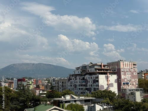 vue sur la ville de Tirana en Albanie avec ses bâtiments et des montagnes en fond un jour nuageux d'été
