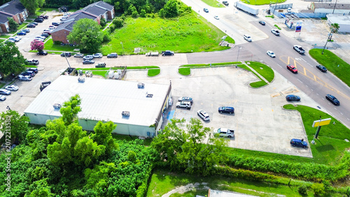 Aerial view of a commercial building with a large parking lot near a busy road