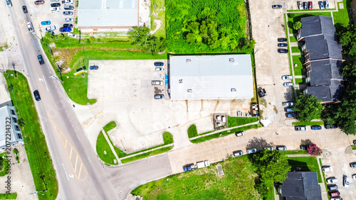 Aerial view of a commercial building with a large parking lot and surrounding area
