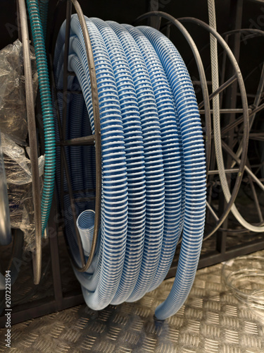 Fotografia Blue corrugated hose wound into a neat coil is available on retail shelves in a