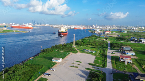 Fotografie Massive marine vessels move toward industrial refineries as they pass through Harbor shipping lanes