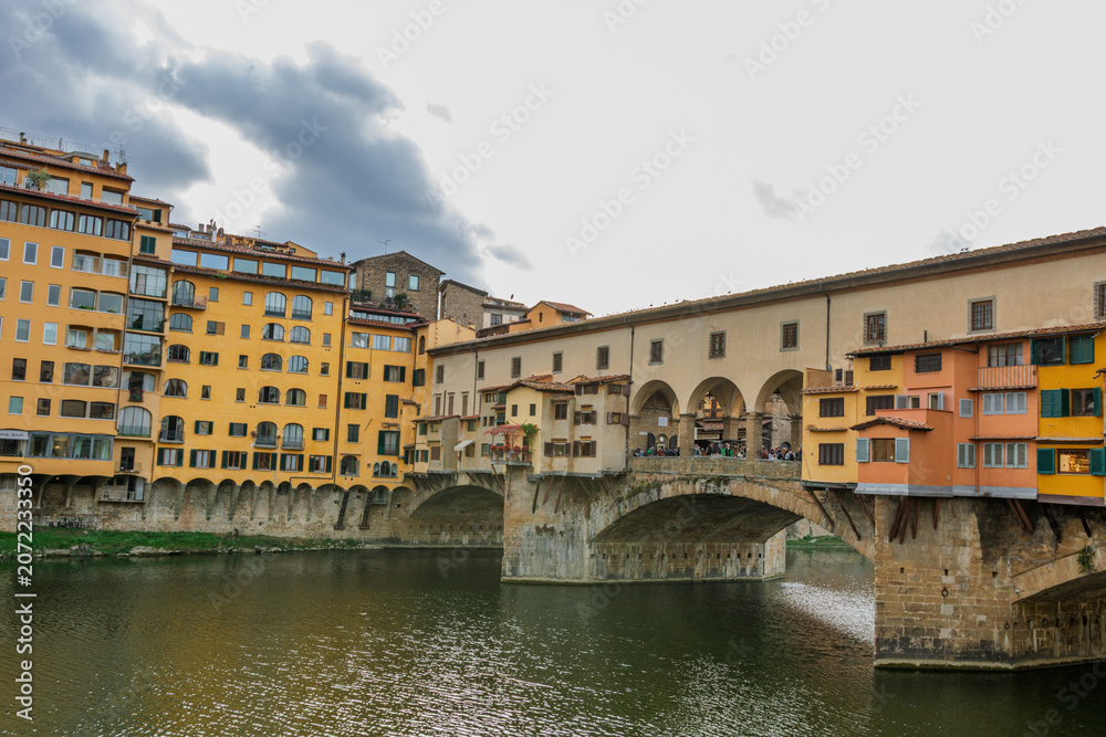 Fototapeta premium Famous historic Ponte Vecchio bridge and old buildings along the Arno river in Florence Italy