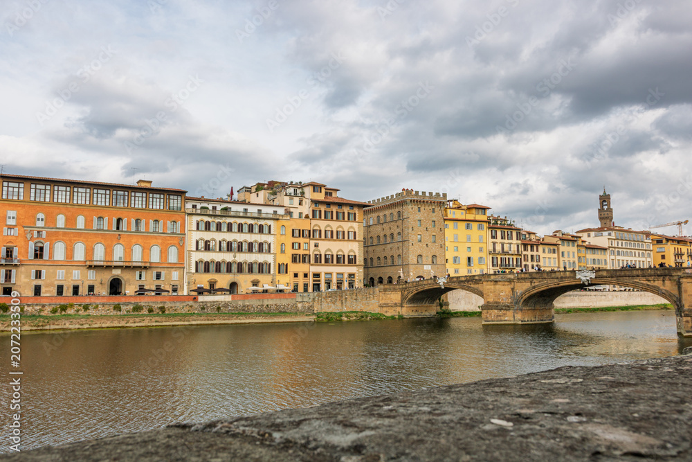 Fototapeta premium Famous historic Ponte Vecchio bridge and old buildings along the Arno river in Florence Italy