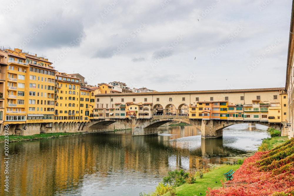 Fototapeta premium Famous historic Ponte Vecchio bridge and old buildings along the Arno river in Florence Italy