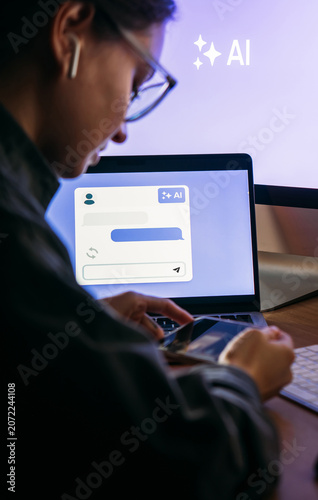 Young woman writing AI promt in a modern office.