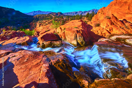 Vivid Waterfall Flow Over Red Rocks in Scenic Utah Desert Landscape