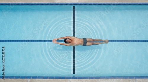 Swimmer performing butterfly stroke in a competition pool from a high angle view High intensity athletic performance