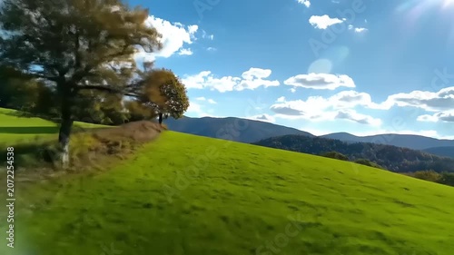 Green hillside landscape with bright sky and clouds in the daylight