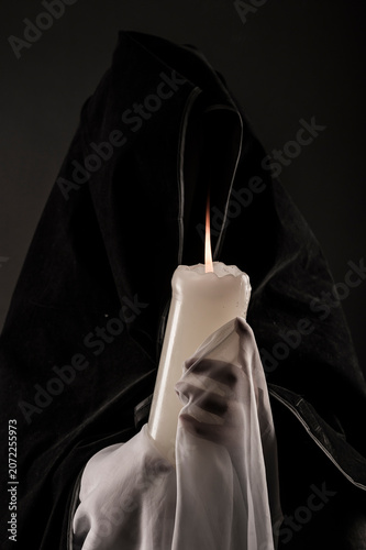 Foto Dark apparition of a woman draped in tulle, holding a large candle