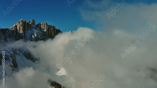 Flying through clouds between mountains