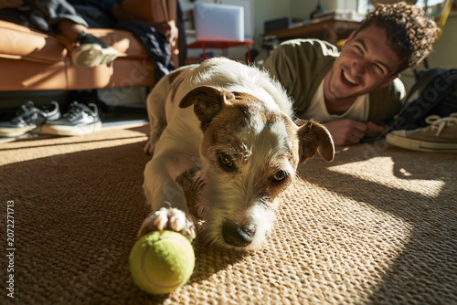 Young man shares joyful moments with his playful dog on a sunny afternoon