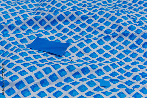 Repairing holes in an above ground pool liner with patches in the backyard