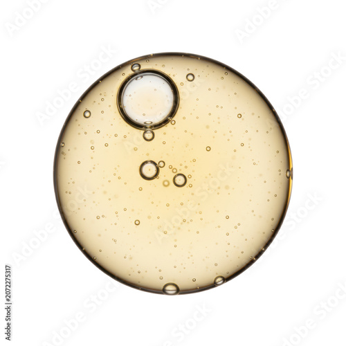 A perfectly spherical, transparent golden cosmetic oil droplet with air bubbles, isolated on a transparent background under soft studio lighting. Concept of scientific precision and luxury skincare