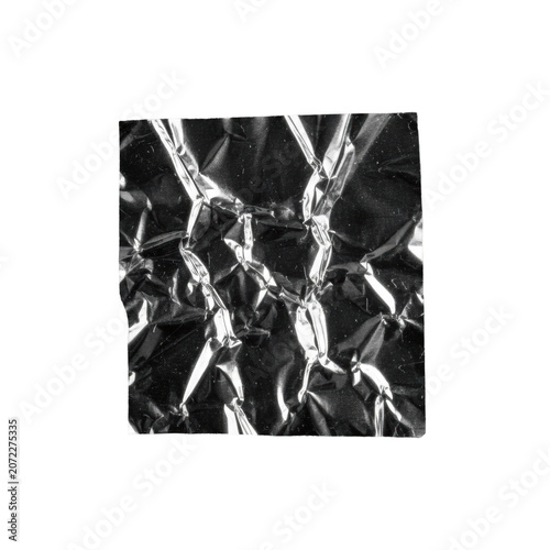 Crumpled metallic sheeting, mirror finish, sharp creases, on gritty charcoal substrate with dust, high-contrast black and white studio macro, raw industrial materiality