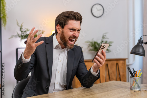 Εκτύπωση καμβά Middle-aged businessman at home office spends money on online lottery casino smartphone app groans as luck fails