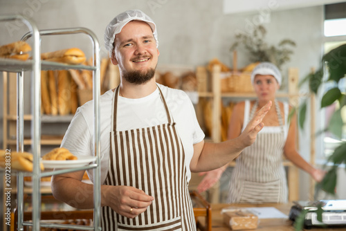 Obraz na płótnie Satisfied young male employee faces away as a young female colleague looks upset