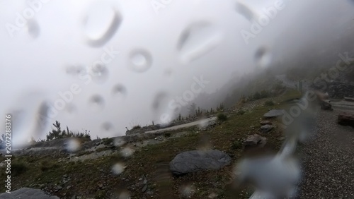 Raindrops on window overlooking foggy mountain trail wilderness exploration