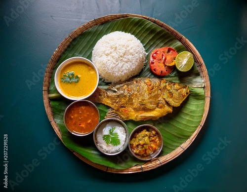 bengali traditional fish thali served on banana leaf with rice dal and vegetables for home lunch