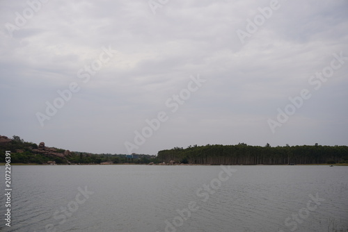 Tranquil reservoir landscape with distant forest and cloudy weather