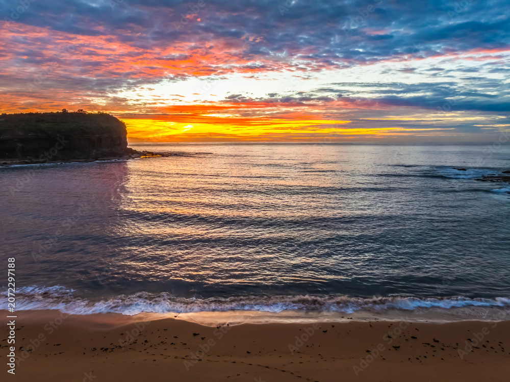 Obraz premium Sunrise Seascape with Calm Seas and a Cloud Covered Sky