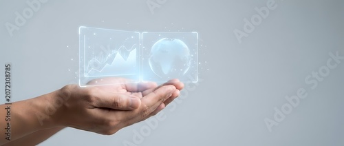 Close-up of male hand holding glowing holographic data analytics interface with chart and pie graph icons, representing digital business intelligence and financial technology solutions.