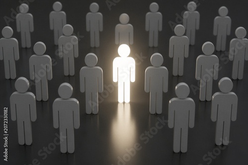 Illuminated human icon standing among grey figures in crowd