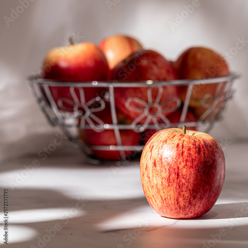 An arrangement of gala apples with a cucoloris modifier casting unique shadows.
