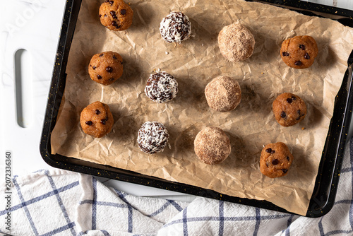 Freshly made delicious high protein energy balls on a baking sheet.