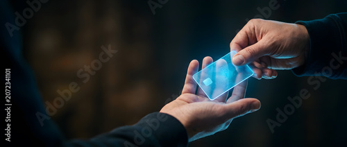 Two hands exchanging glowing transparent digital credit card with blue circuit pattern
