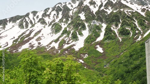 初夏の観光名所立山黒部アルペンルートの立山ロープウェイの様子と山の残雪と新緑の風景