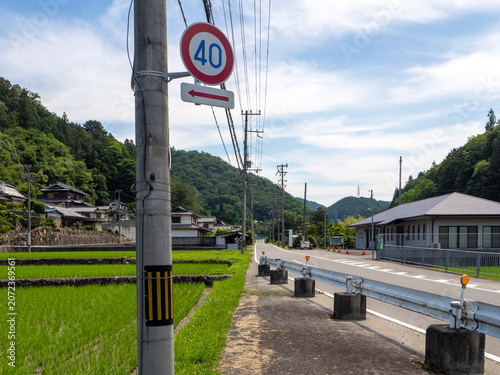 山間を通る道路と水田の風景