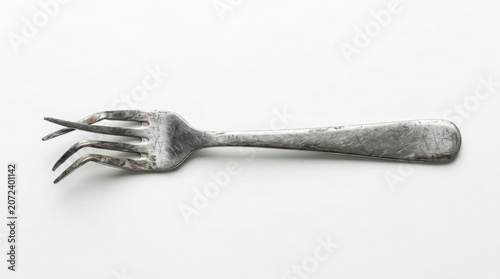 Bent metal fork with damaged prongs isolated on white background minimalist still life