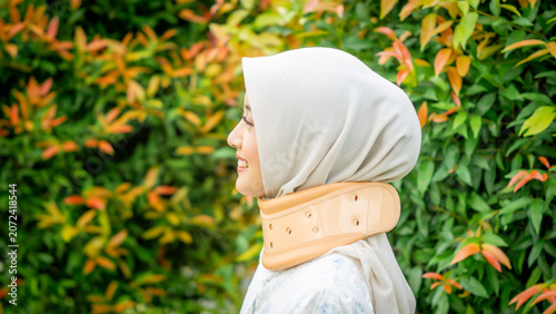 A young Asian Muslim woman wearing a Cervical Collar. Neck injury.