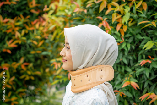 A young Asian Muslim woman wearing a Cervical Collar. Neck injury.