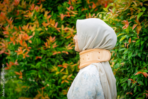 A young Asian Muslim woman wearing a Cervical Collar. Neck injury.