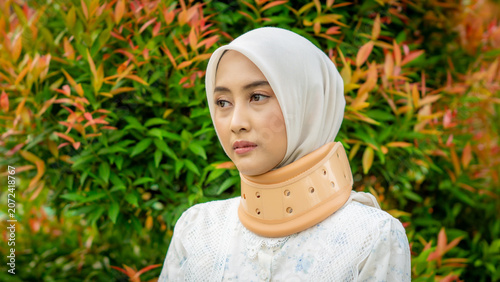 A young Asian Muslim woman wearing a Cervical Collar. Neck injury.