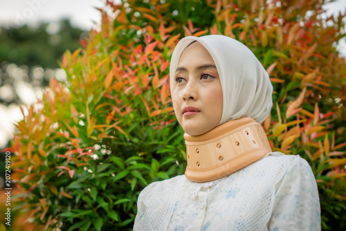 A young Asian Muslim woman wearing a Cervical Collar. Neck injury.
