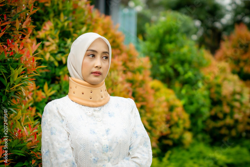 A young Asian Muslim woman wearing a Cervical Collar. Neck injury.