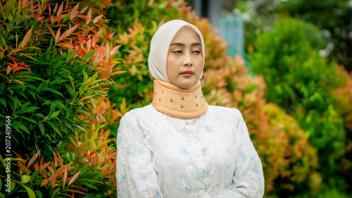 A young Asian Muslim woman wearing a Cervical Collar. Neck injury.