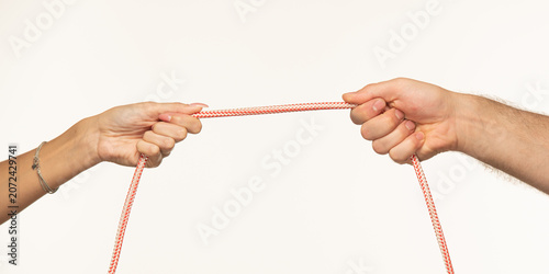 Canvastavla Female and male hands pulling a rope towards themselves on a white background