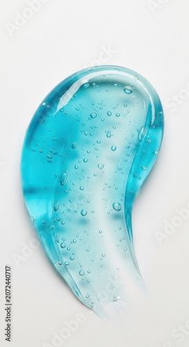 Droplet of blue gel on a white surface showing small bubbles and texture