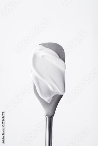 Bild auf Leinwand Close up of white cosmetic cream or body lotion smear on metal skincare spatula