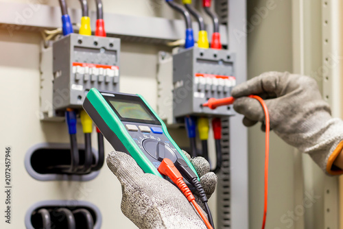 Engineers working to inspect and maintain electrical control cabinets.
