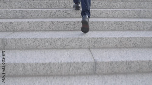 Business man climbing stairs outdoors in the city. Businessman step by step on stairs building a career. Business man walking stairs as a success concept. Businessman climbing stairs for growth.