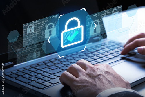 Cybersecurity Lock Icon on Laptop: A close-up shot shows hands typing on a laptop keyboard.