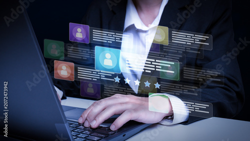 Digital Networking Interface: A close-up view shows a person's hands typing on a laptop, interacting with a futuristic digital interface displaying user profiles and data.