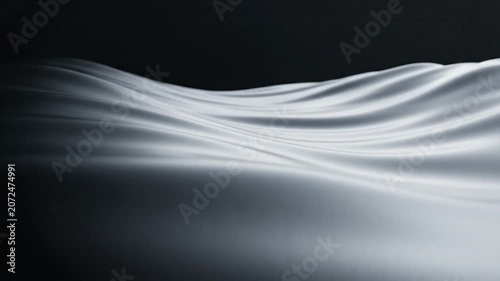 Abstract dark waves of smooth silk fabric in low light