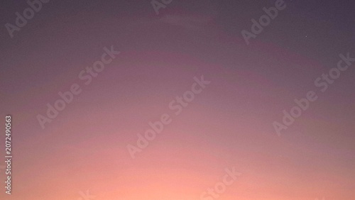 Peaceful twilight sky background with gentle pastel gradient from orange to deep purple