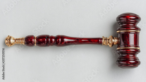 Traditional dark wood judge gavel with gold band detail legal system gray background decision